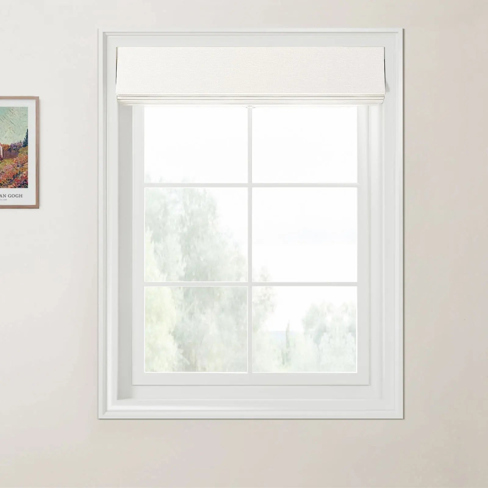 Van Gogh print of a rural landscape framed on a light beige wall next to a white multi-pane window with a textured white Roman blind revealing blurred green foliage outside