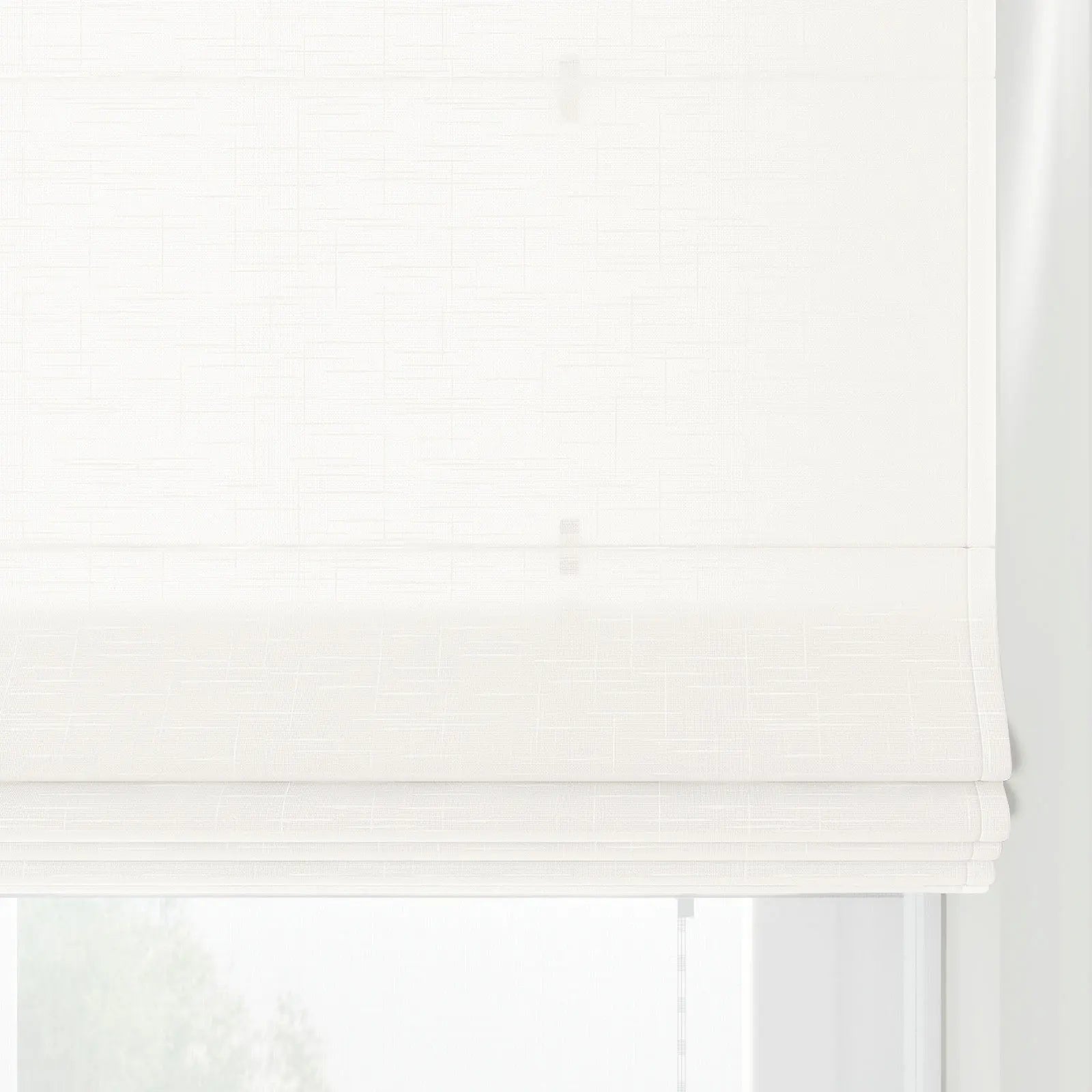 White Roman blind with a subtle grid pattern linen-like texture, partially lowered in a window with distinct horizontal folds