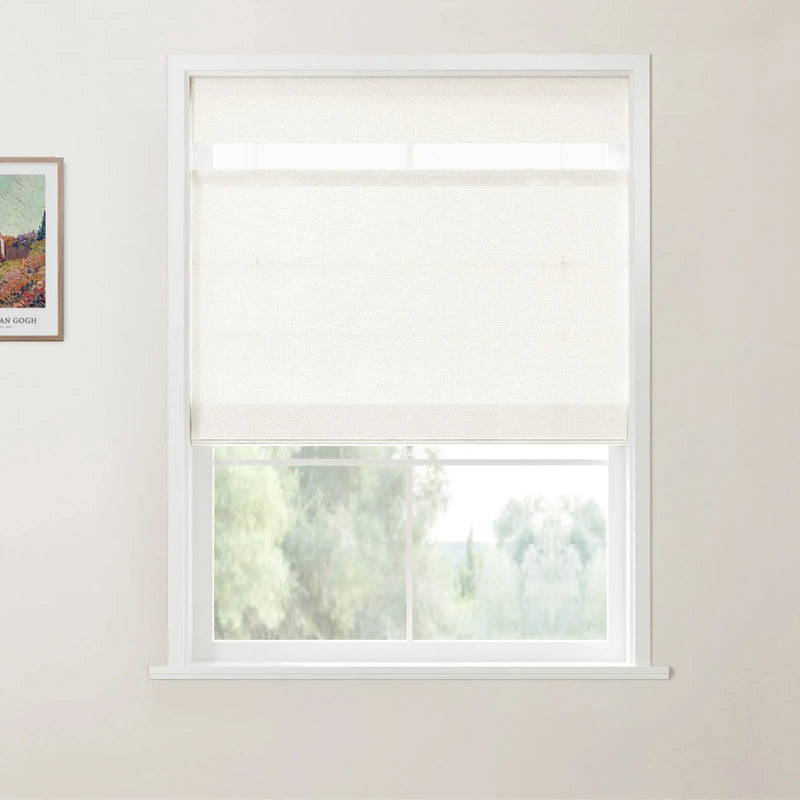 A photograph of a white-framed window with a light beige textured roller blind partially lowered, overlooking a natural scene of blurred green trees, and a framed Van Gogh art print on the left white wall
