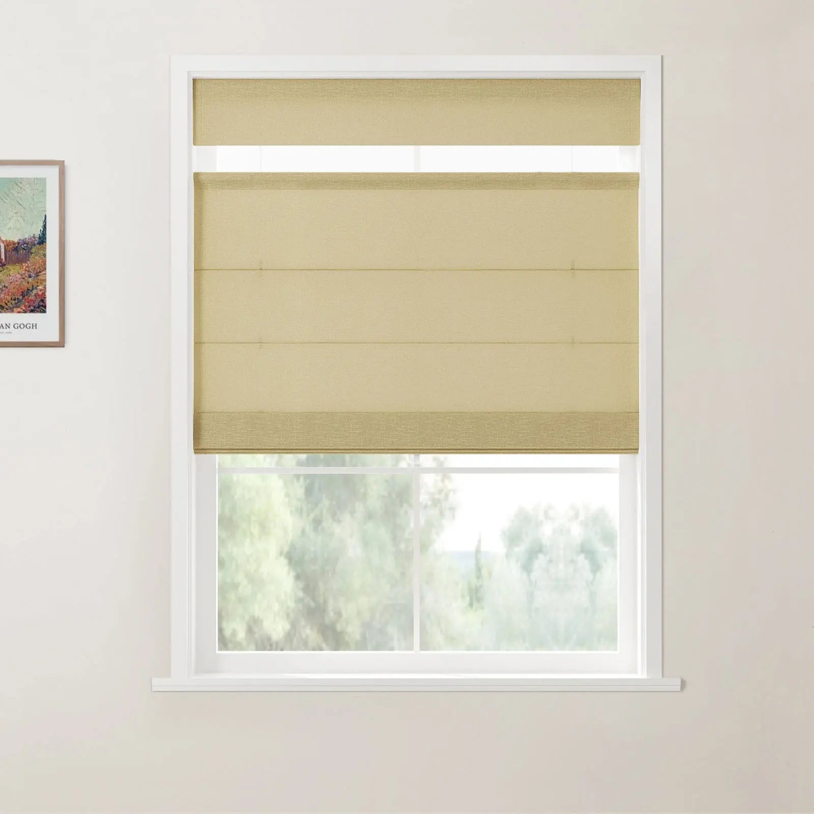 Print of Van Gogh's Farmhouse in Provence hanging next to a window with double-layered beige Roman blinds providing a soft view of green trees