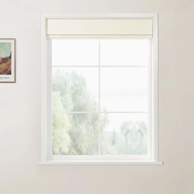 Photograph of a bright room featuring a white-framed window with a cream Roman shade, overlooking blurred green trees, with a framed Van Gogh print visible on the light beige wall
