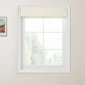 Photograph of a bright interior room featuring a white six-pane window with a cream textured Roman blind partially pulled up a framed Van Gogh art print on the left wall and a hazy green outdoor landscape visible through the glass
