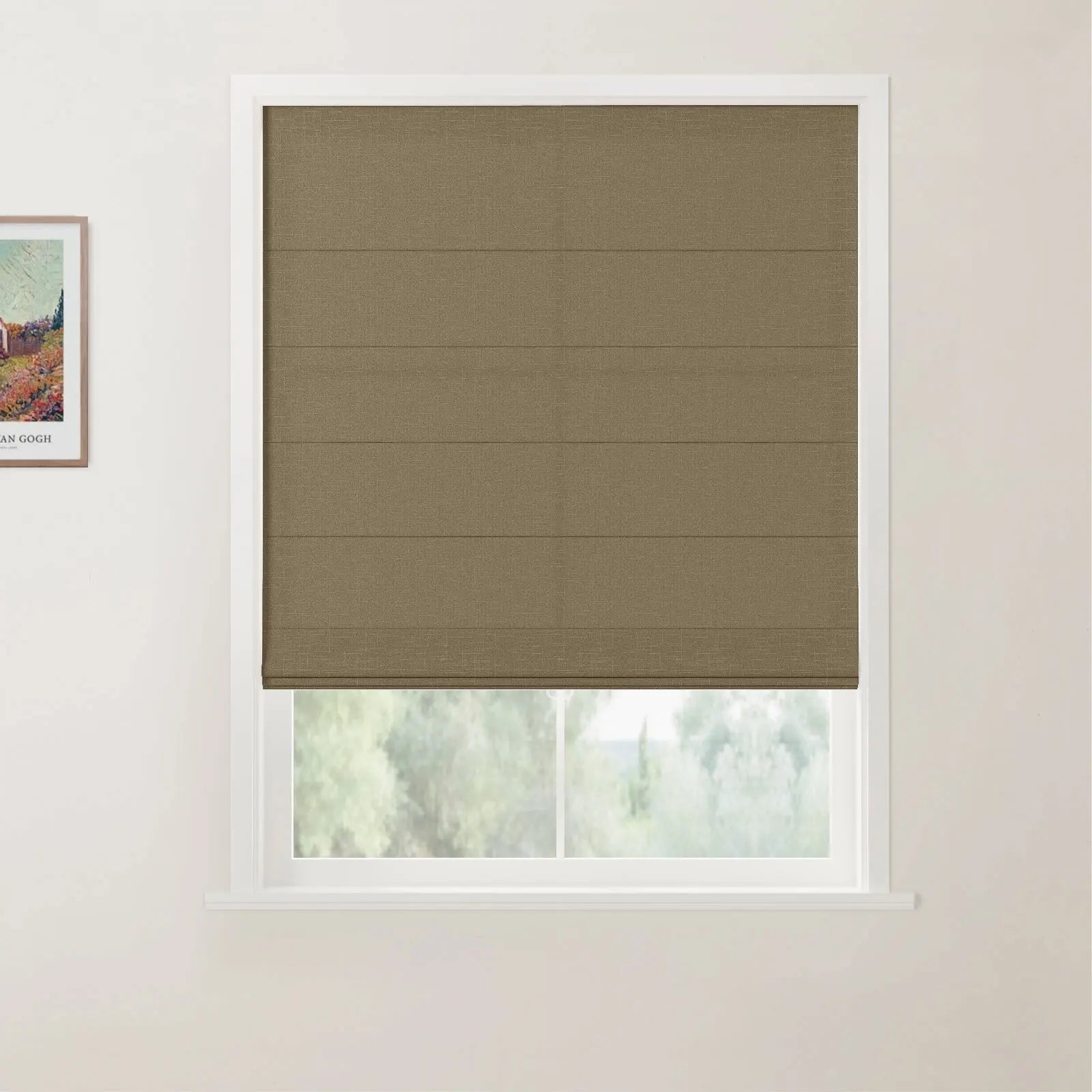 Photograph of a partially raised brown woven textured Roman blind in a white framed window against a light wall, featuring a blurred green outdoor view and a corner of a Van Gogh print