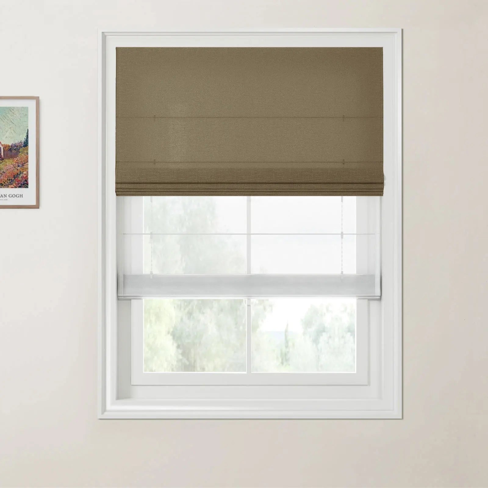 A framed Van Gogh print and a window with a dark brown Roman blind and white sheer blind on a cream wall