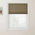 Print of a Van Gogh landscape painting on a light beige wall beside a white window frame with a brown textured Roman blind pulled halfway