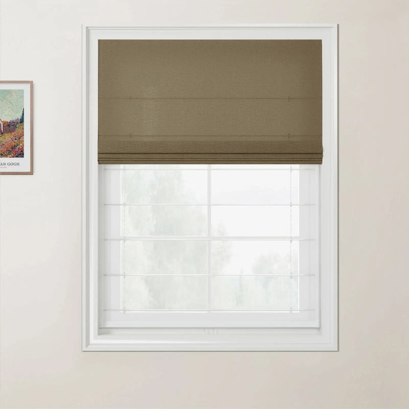 Print of a Van Gogh landscape painting on a light beige wall beside a white window frame with a brown textured Roman blind pulled halfway