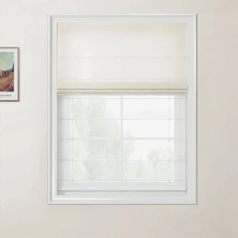 Photograph of a modern interior featuring a cream Roman blind half-closed over a white grid window looking out to blurred green trees, with a framed Van Gogh landscape print on the pale beige wall