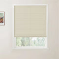 Photograph of a window with a cream textured roman blind and white frame, a framed Van Gogh print on the adjacent white wall, looking out to blurred green trees