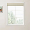 Photograph depicting a white multi-pane window with a light beige Roman shade revealing a blurred green landscape, with a framed Van Gogh print showing a house and colorful fields on the adjacent wall