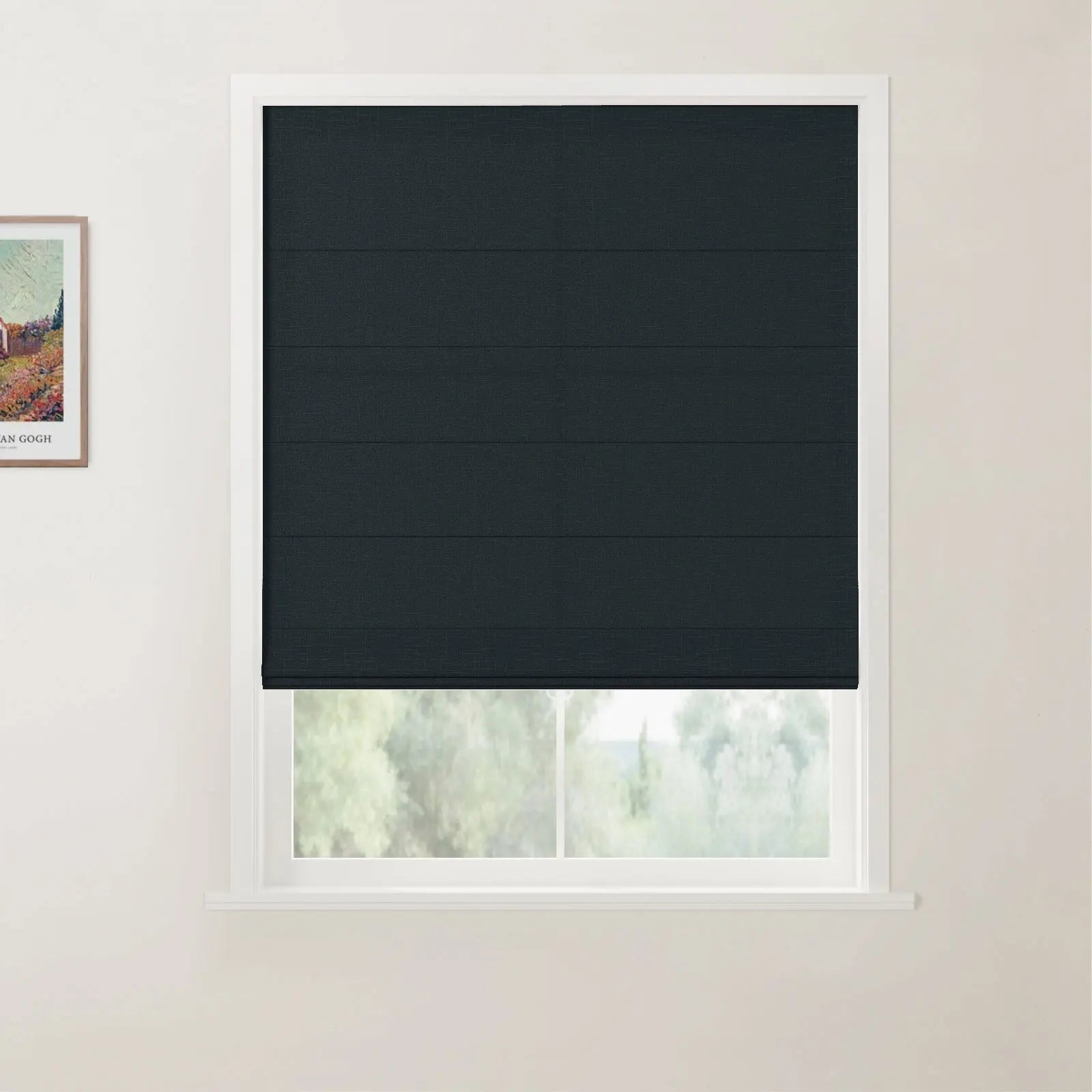 Photograph of a white-framed window featuring a dark charcoal textured Roman blind, partially revealing a vibrant green outdoor view, with a framed Van Gogh print on the adjacent wall