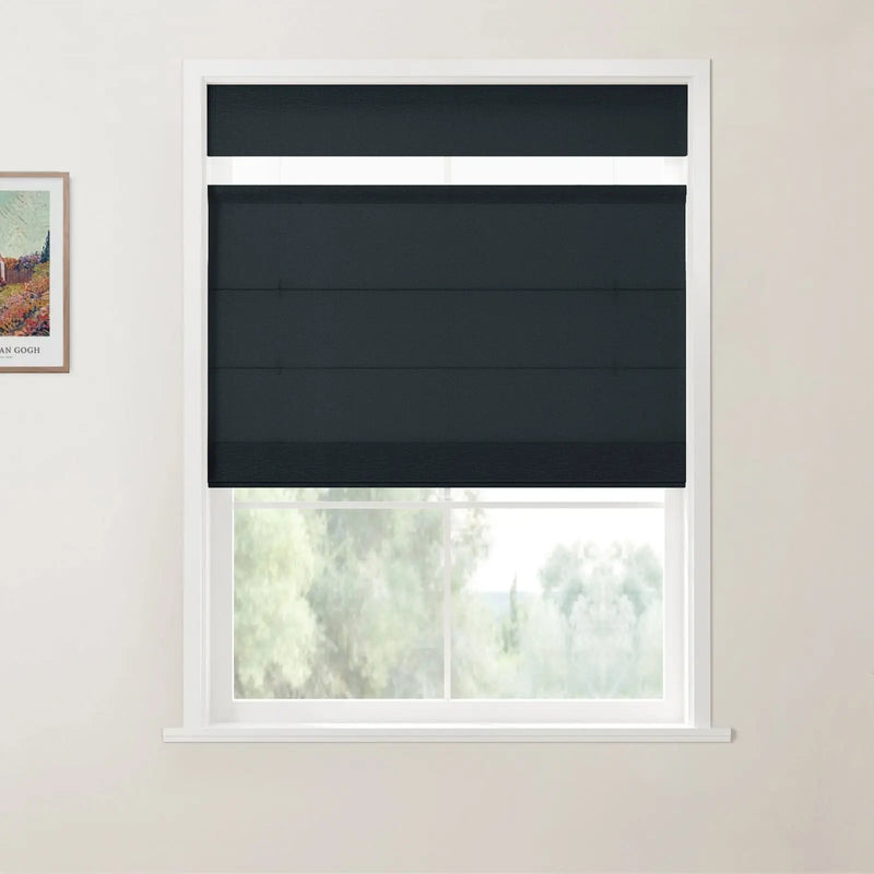 Photograph of a contemporary interior featuring a dark grey layered zebra blind on a white-framed window, with a framed Van Gogh print on the light cream wall and blurred green foliage outside