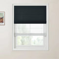 Photograph of a modern home interior featuring a white framed window with dual layered blinds, including a dark grey Roman blind above a sheer white blind, alongside a partially visible framed Van Gogh landscape print on the light beige wall