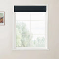 Photograph of a modern interior featuring a white grid window with a dark blue textured roller blind, a blurred natural landscape visible outside, and a framed Van Gogh print on the beige wall
