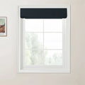 Photograph of a white multi-pane window with a dark navy blue textured Roman blind and a framed Van Gogh print on the adjacent light beige wall, offering a blurred view of green trees outside