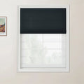 Photograph featuring a dark grey roman blind covering part of a white grid window in a room, with a framed Van Gogh print on the left wall