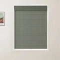 Photograph showing a modern interior with a white-framed window featuring a textured dark olive green Roman blind with horizontal folds and a darker top valance, positioned next to a framed vibrant Van Gogh print on a light cream wall
