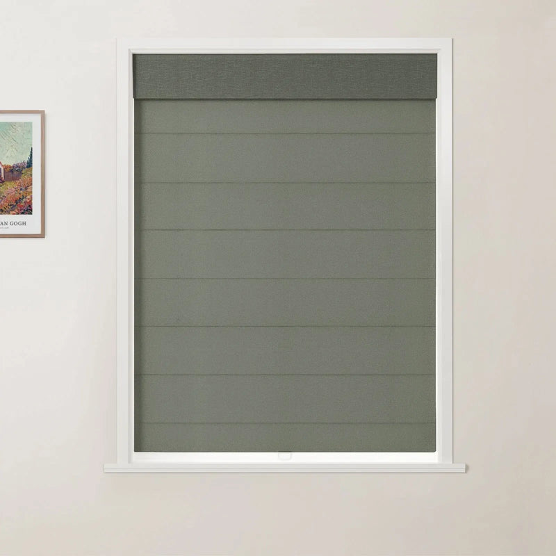 Photograph showing a modern interior with a white-framed window featuring a textured dark olive green Roman blind with horizontal folds and a darker top valance, positioned next to a framed vibrant Van Gogh print on a light cream wall