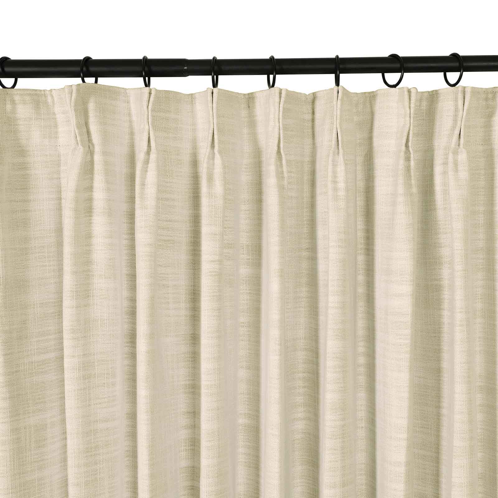Photograph of a cream linen-look pleated curtain hanging from a black rod with rings