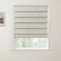 Photograph of a white-framed window featuring a beige textured Roman blind partially open to a blurred green outdoor view, positioned next to a framed Van Gogh landscape print