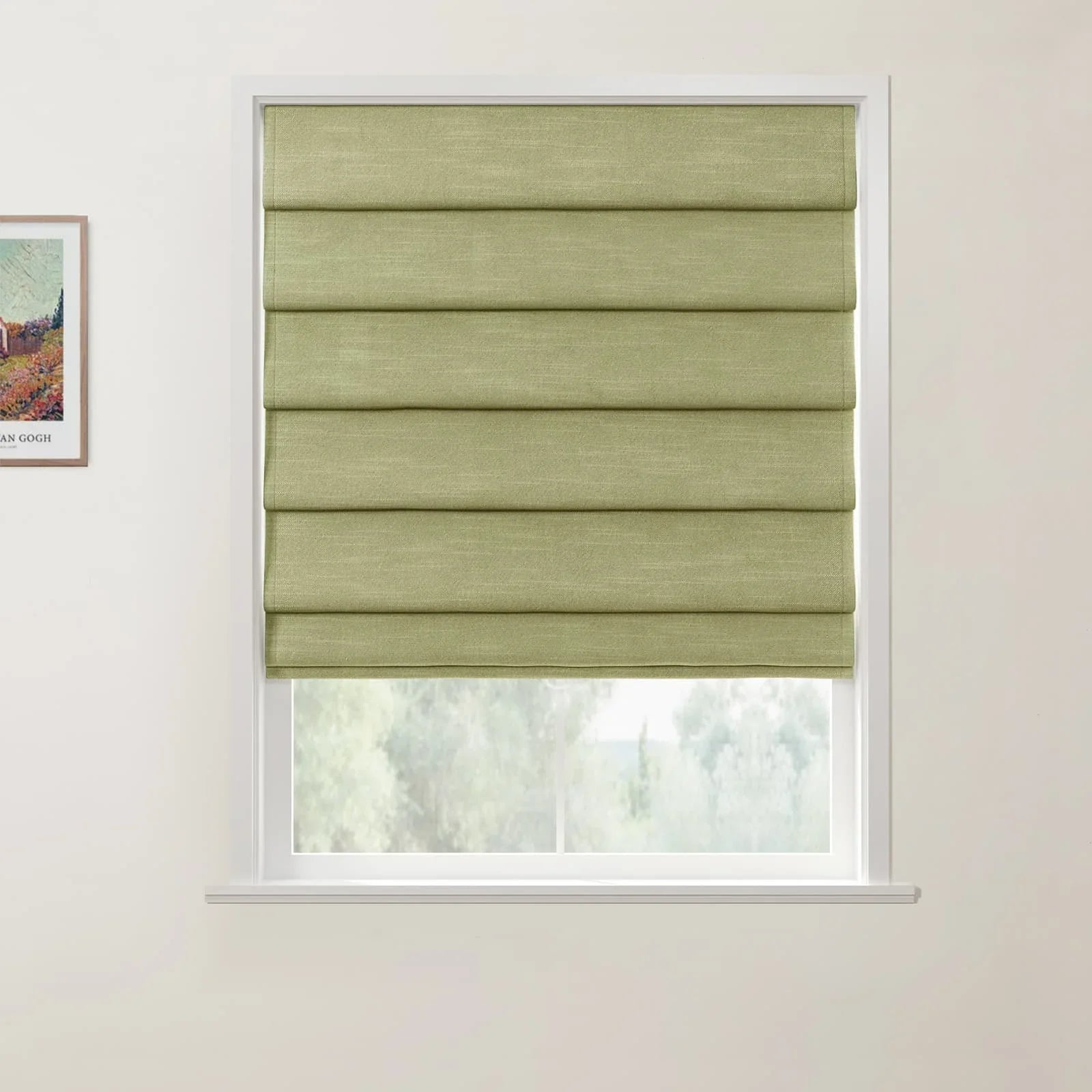 Light green textured fabric roman blind partially covering a white window frame revealing blurry trees, with a framed Van Gogh art print on the wall
