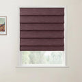 Print by Van Gogh on a white wall beside a white window frame with deep plum textured Roman blinds partially open to blurry green foliage