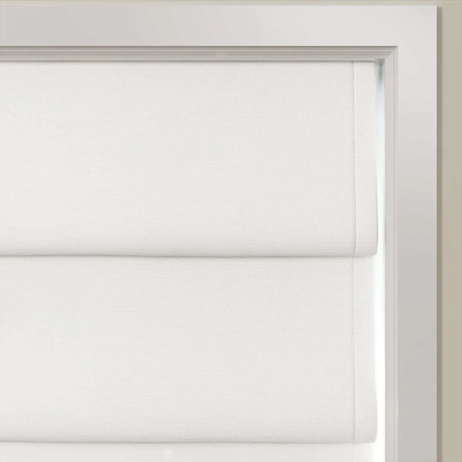 White textured cellular blinds covering a window within a bright white frame featuring soft horizontal pleats