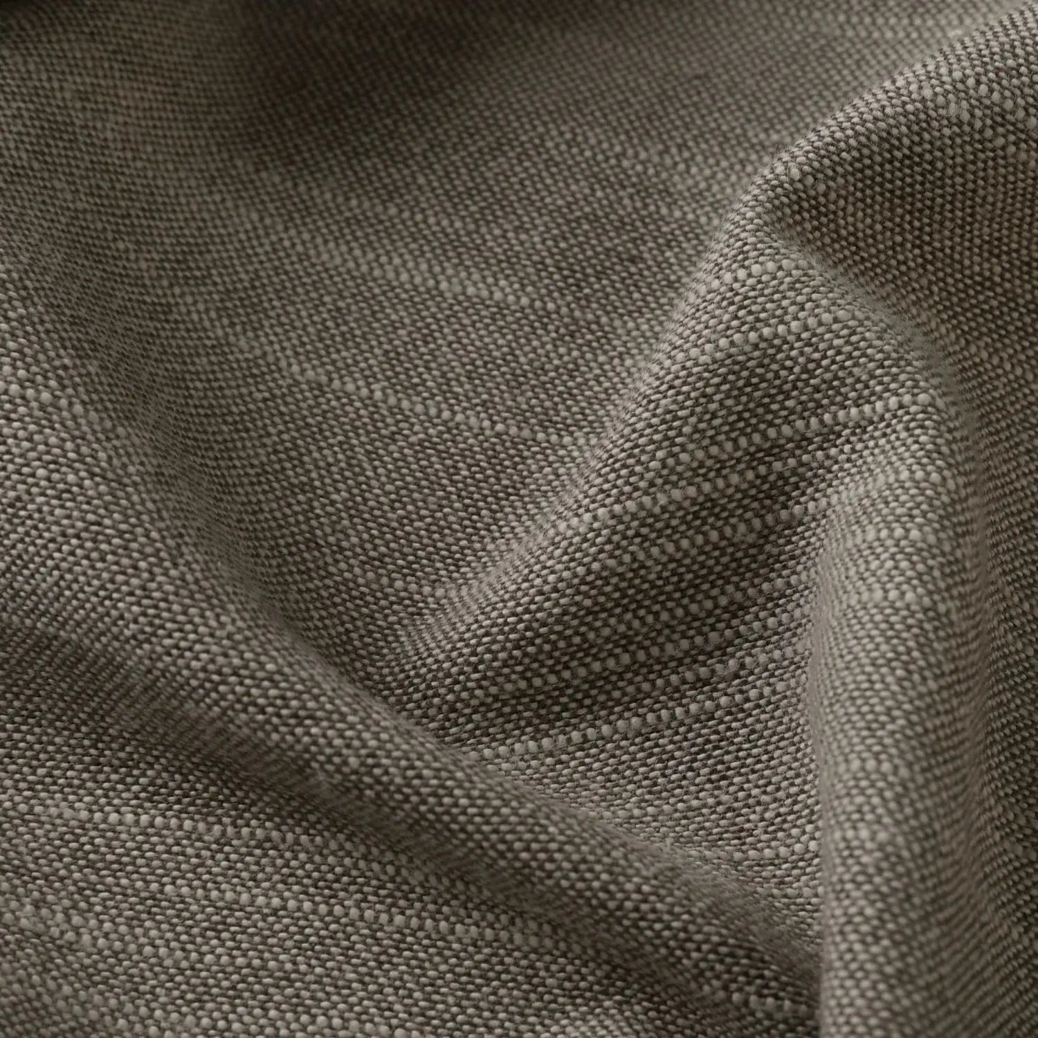 Rustic grey woven fabric displaying a tight textured weave with subtle flecks and gentle undulating folds