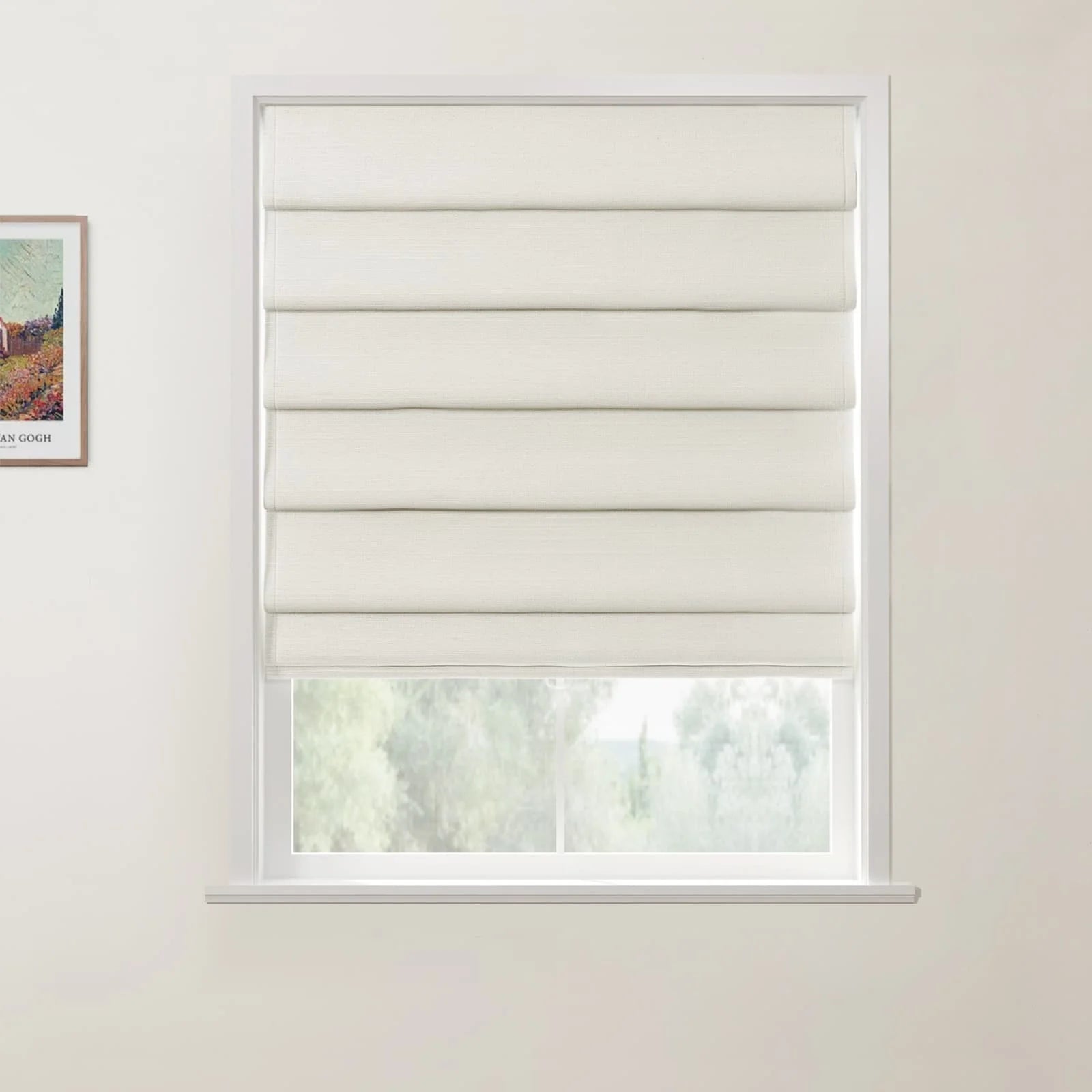 Photograph of a white-framed window featuring neatly stacked cream Roman blinds in an interior room, with a partially visible Van Gogh print on the left wall and blurred green foliage outside