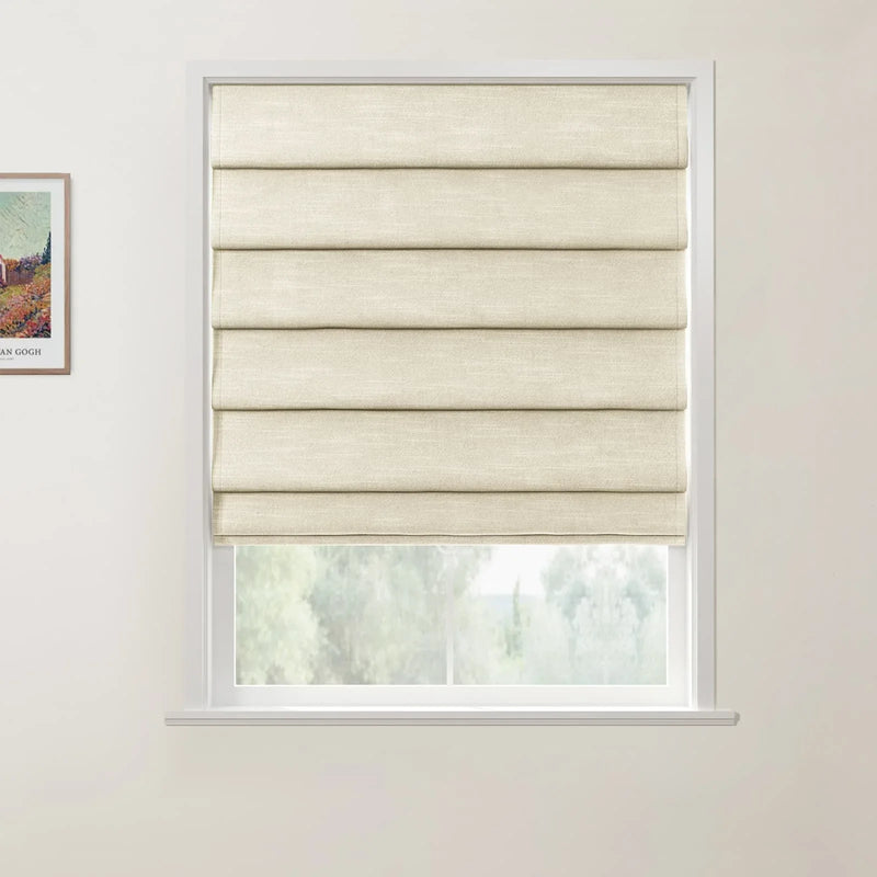 Photograph featuring a framed Van Gogh print showing a colorful landscape, alongside a window with a textured beige Roman blind partially raised to reveal blurred green trees outside against a plain white interior wall