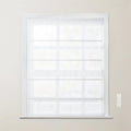 White sheer fabric Roman shade with horizontal folds fully lowered over a window with a white frame and a white wall-mounted remote control