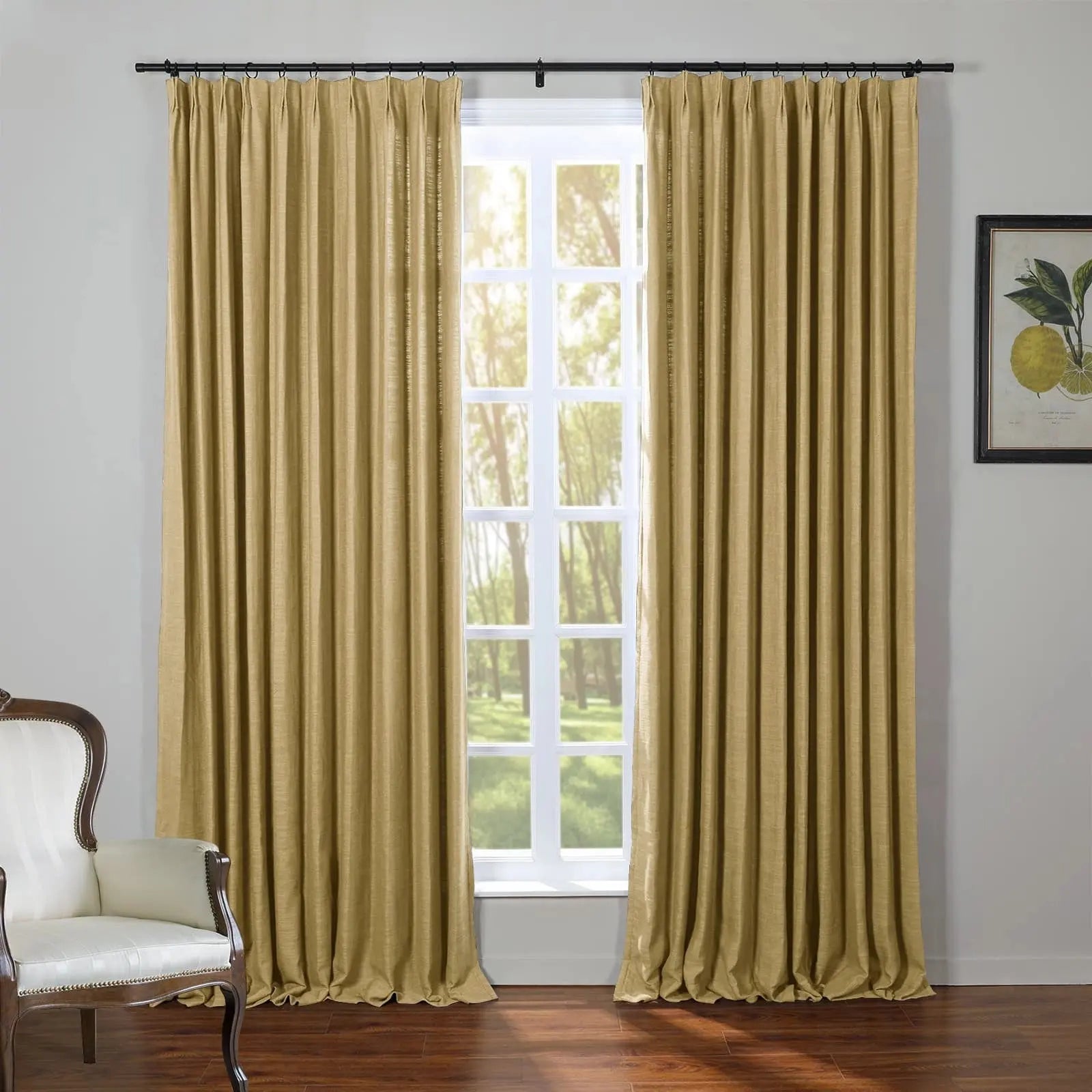 Textured goldenrod pleated curtains frame a sunlit window in a room with a classic cream striped armchair and a vibrant lemon botanical print on the wall above dark wood floors