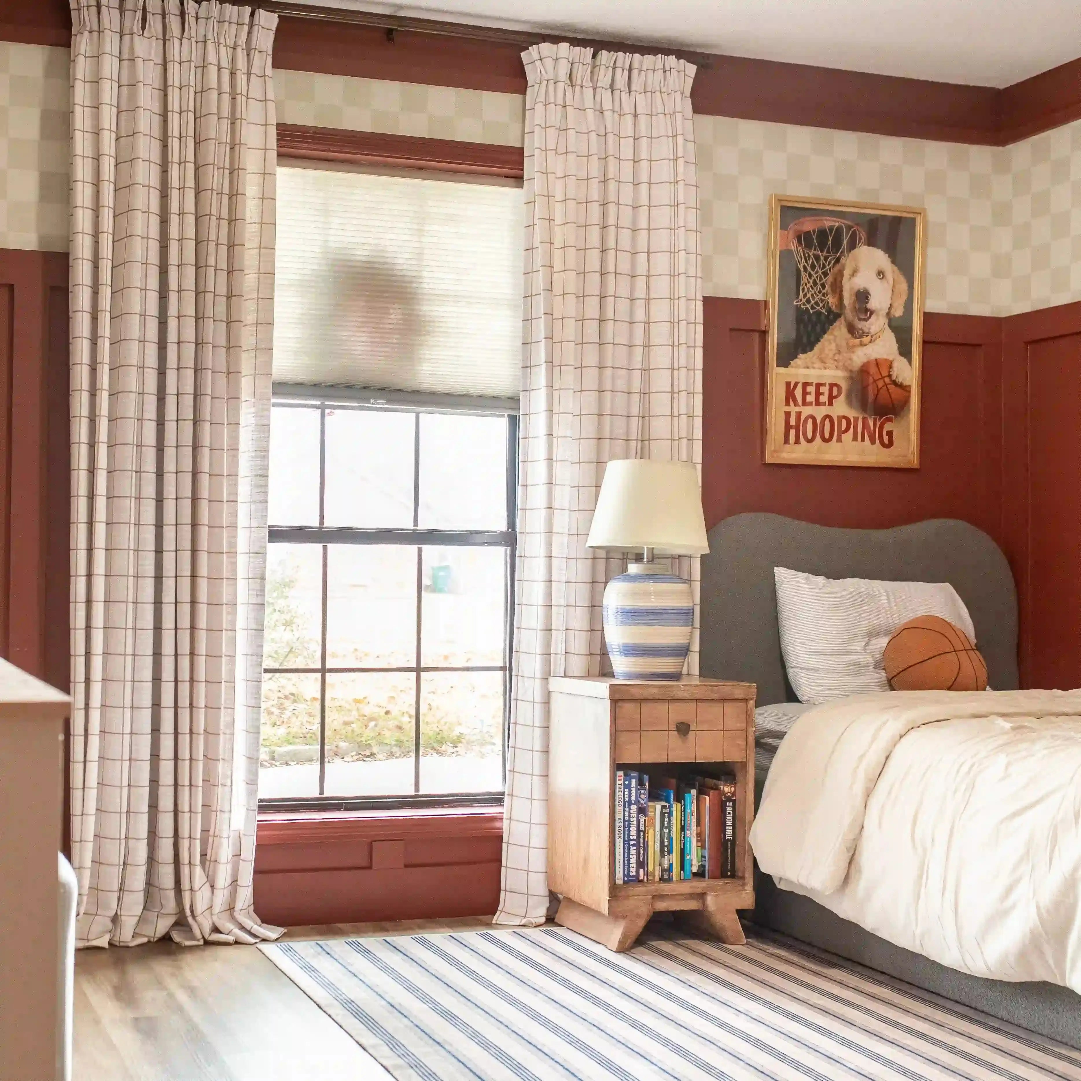 Bedroom with checkered walls, plaid curtains, and a bed with a 'Keep Hooping' poster.