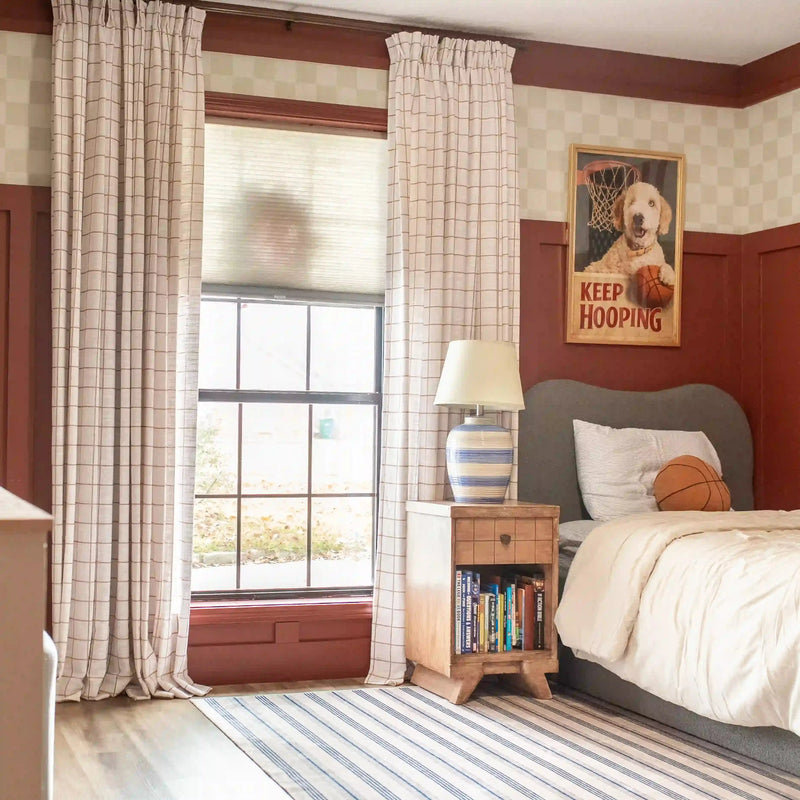 Bedroom with checkered walls, plaid curtains, and a bed with a 'Keep Hooping' poster.