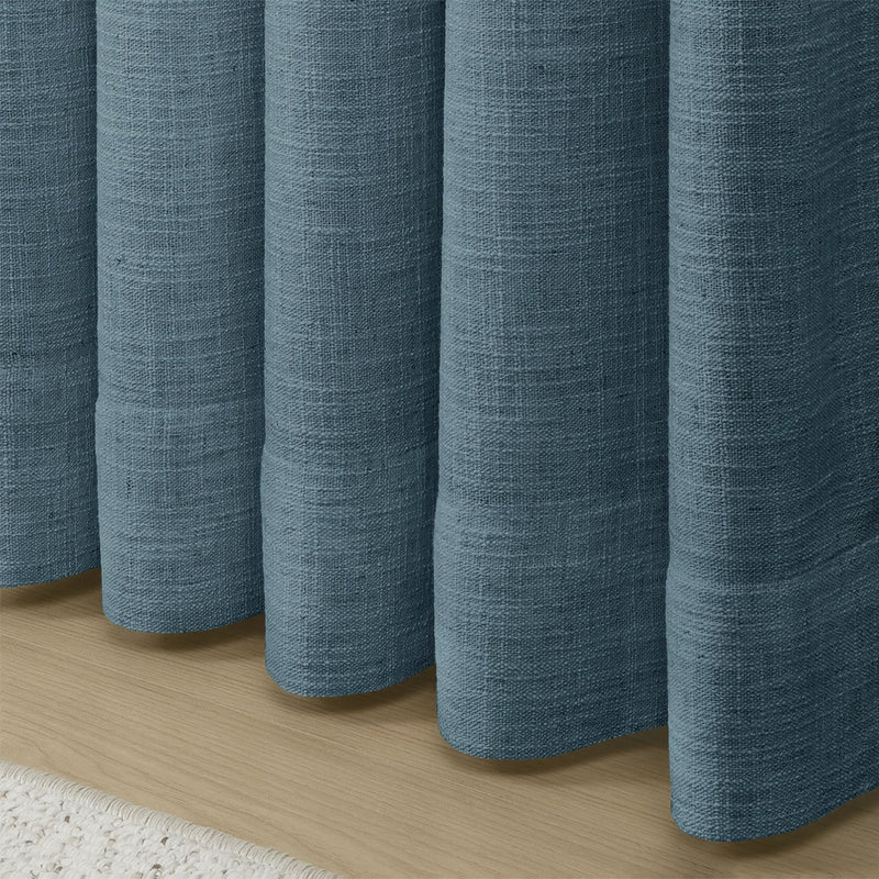 Aegean Blue Liz linen curtains showing the lower drape and pooling folds near the floor