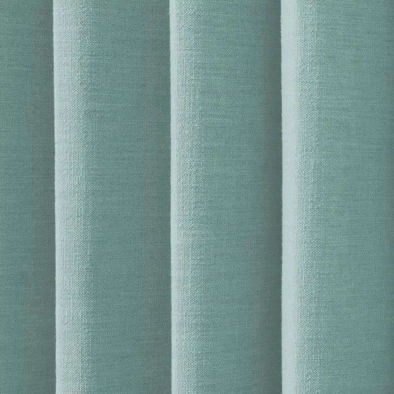 Textured fabric displaying vertical folds in a pale teal color with a woven bouclé texture and subtle light and shadow