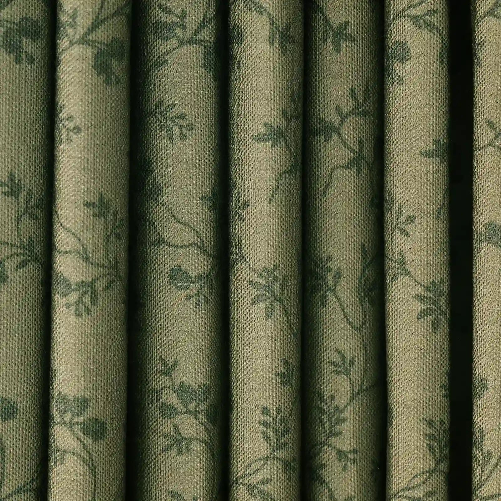 Fabric olive green draped curtains with a subtle raised textured weave and a repeating dark green botanical pattern of leaves and vines