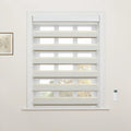 Window with light grey and beige two-tone zebra Blinds in an interior room, featuring a white wall-mounted remote and a framed botanical print on the left wall