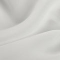 Photograph of white draped fabric featuring elegant undulating folds and a finely textured surface