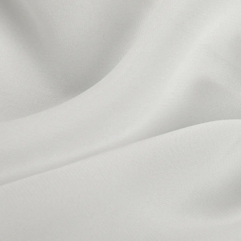 Photograph of white draped fabric featuring elegant undulating folds and a finely textured surface