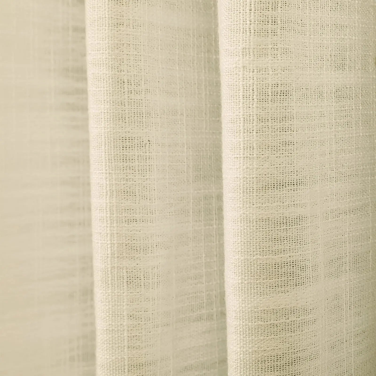 Photograph of a cream-colored linen curtain with a loose weave and soft vertical folds