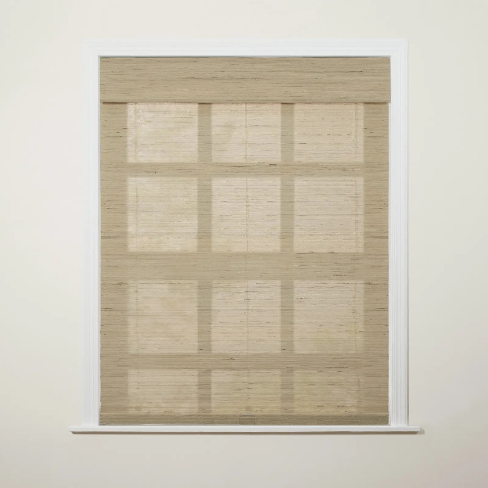 Photograph of a window in an interior room featuring a light beige woven Roman blind with visible horizontal folds and faint grid-like shadows cast upon it from behind, framed by white molding