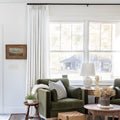 Beige White Liz Linen Pleated Curtains beside a green sofa and dried-flower coffee-table arrangement