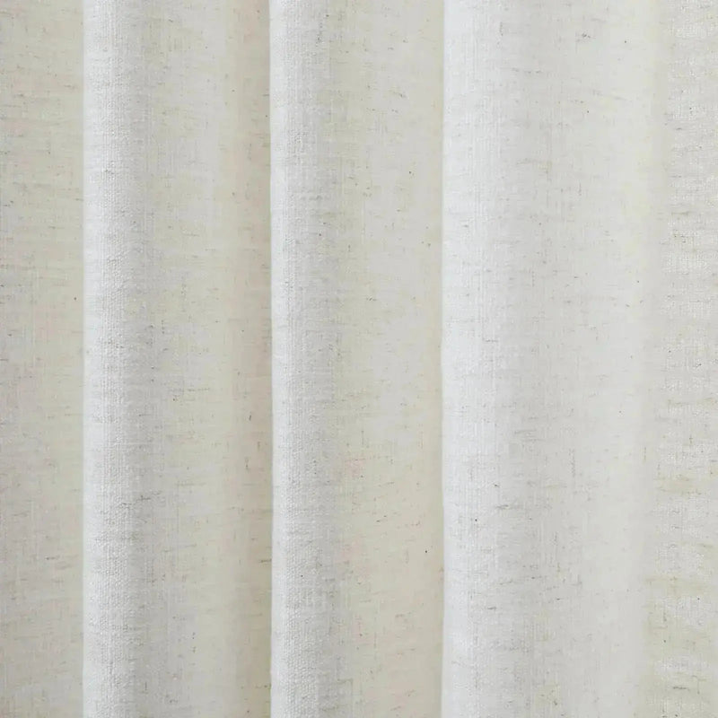 Textile photograph of off-white pleated fabric with a visible natural linen-like weave and subtle dark flecks