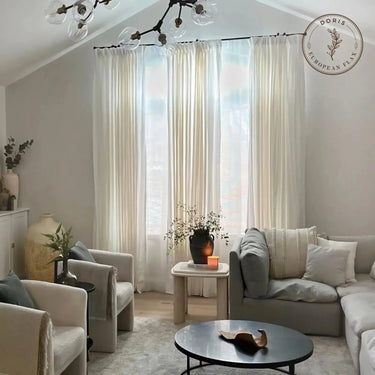 Doris Pure Linen Pleated Curtains - Beige White curtains softly filtering daylight in a vaulted living room with cream seating