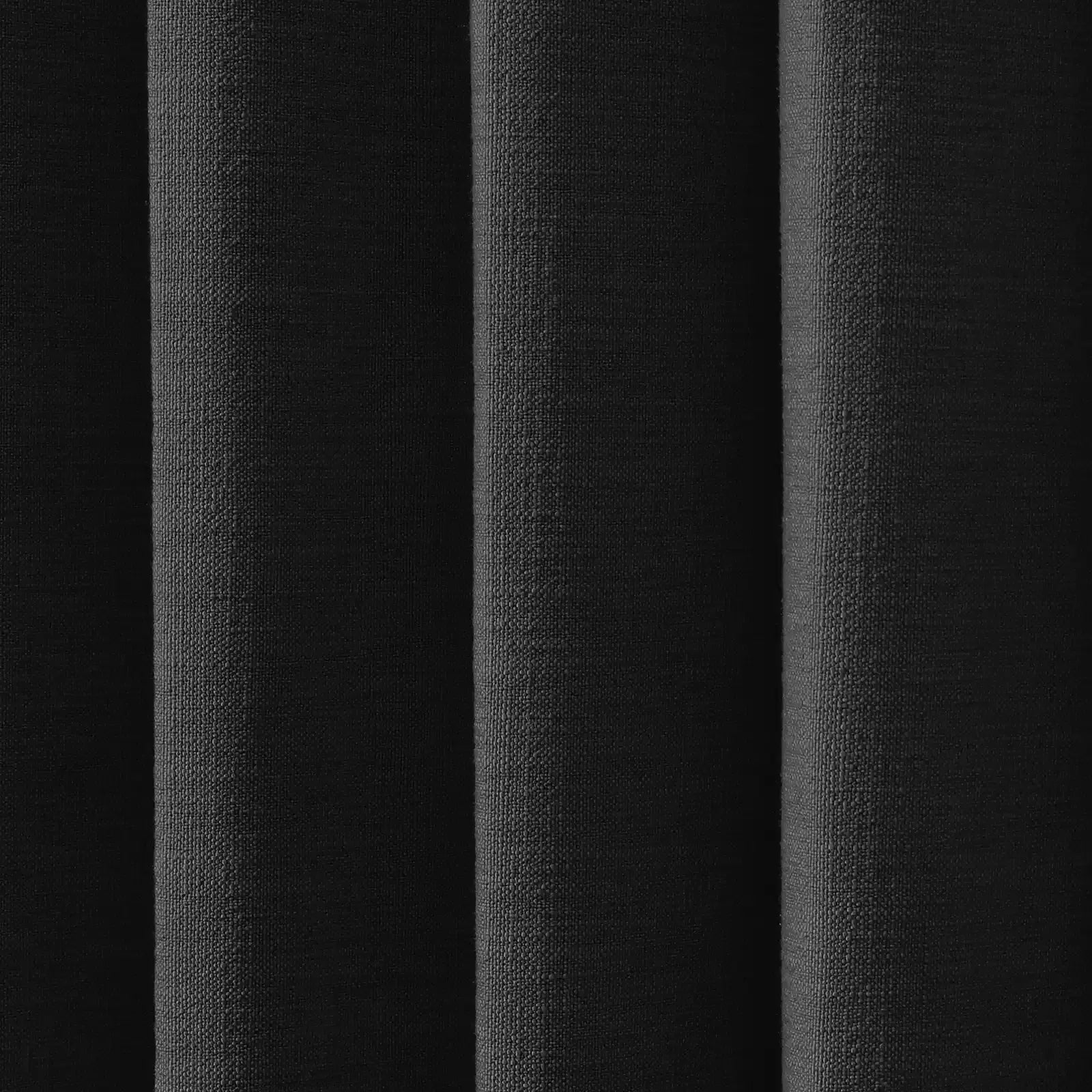 Vertical folds of black coarse woven fabric featuring a subtly pebbled texture and varied shadows creating depth
