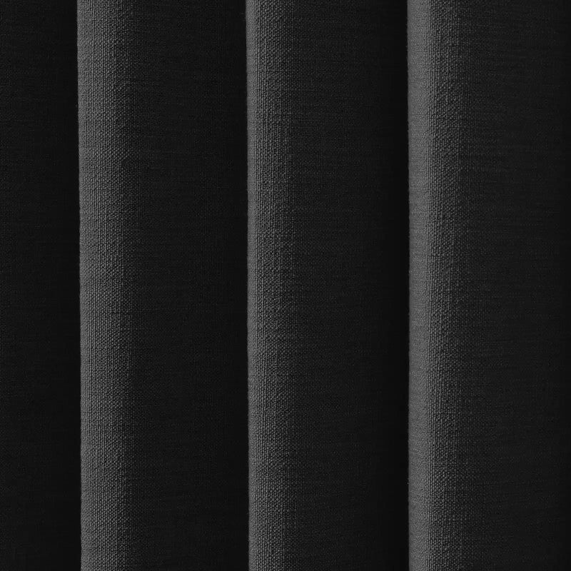 Vertical folds of black coarse woven fabric featuring a subtly pebbled texture and varied shadows creating depth