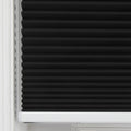 Close-up of a black cellular Blind featuring sharp horizontal pleats, neatly installed within a white window frame with a visible white bottom rail
