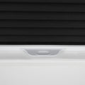 Product photography of a close-up detail of black textured cellular window Blinds partially lowered in a white window frame with a white plastic pull tab handle