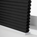 Photograph of black cellular Blinds with a textured honeycomb fabric and a crisp white bottom rail on a window