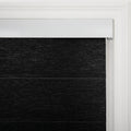 Close-up of a black textured fabric layered window Blind with a white headrail and a classic white molded window frame in an interior setting revealing the control cord